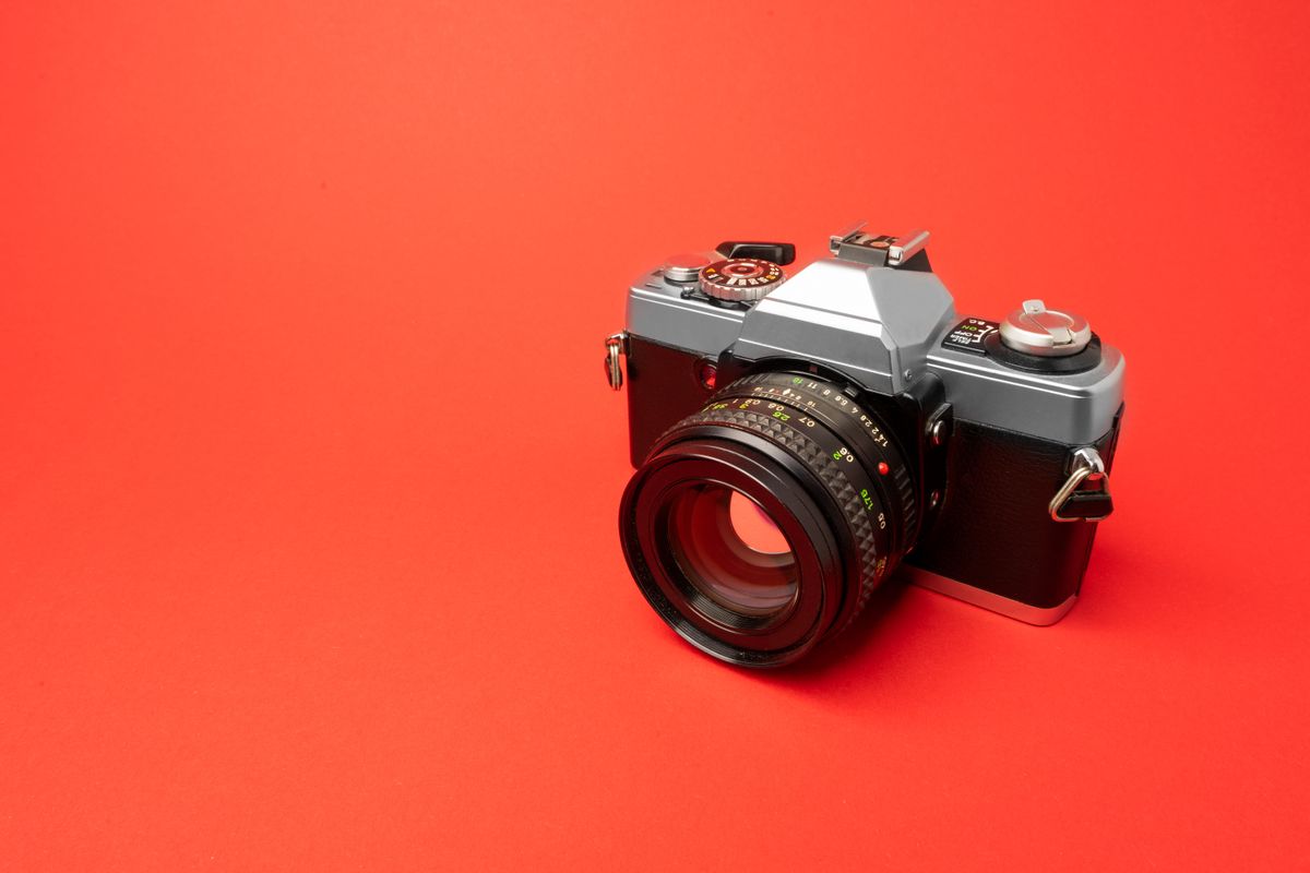 A film camera on an orange surface